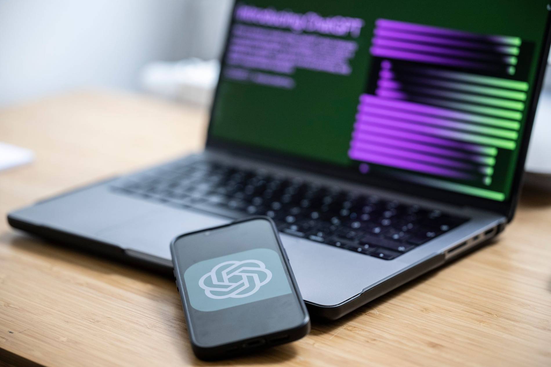 Computer und Handy auf dem ein KI-Chat Programm ge&ouml;ffnet ist