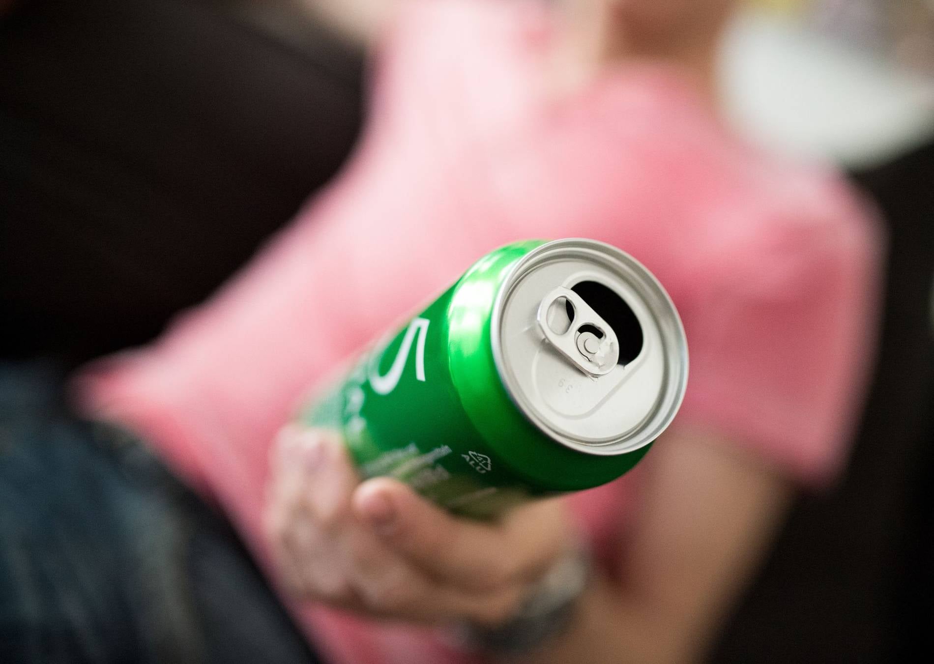 Eine Person h&auml;lt eine ge&ouml;ffnete Getr&auml;nkedose in der Hand.